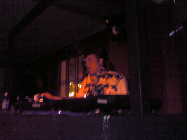 a dj in yellow and black shirt plays music