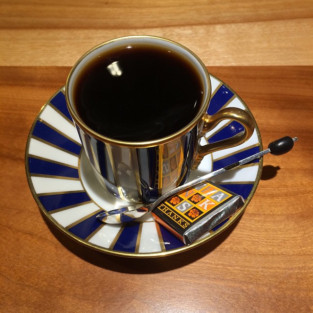 a cup of black coffee is sitting on a saucer