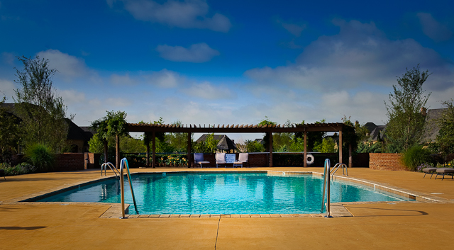 a swimming pool with an attached gazebo and patio furniture