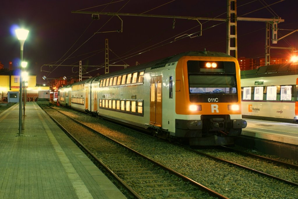 a train stopped at a train station during night