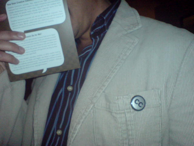 a man wearing a jacket and tie holding a paper with one hand