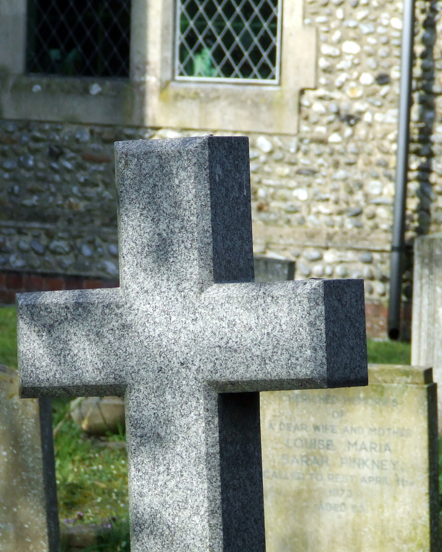 two headstones of different kinds and colors are on either side of each other