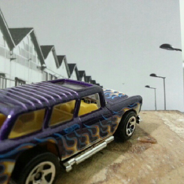 a purple truck sitting in front of a tall white building