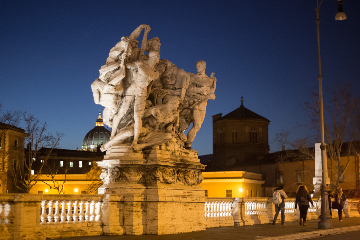 a group of people standing outside by a sculpture