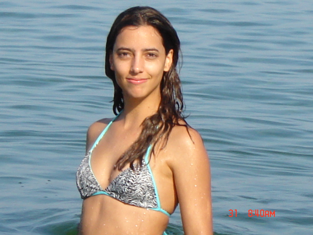 a girl with long hair in a bikini is posing for the camera