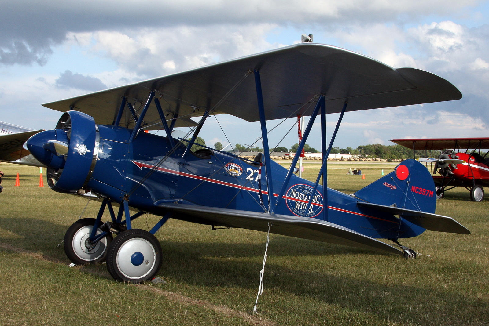 an old style blue plane on display in an open field