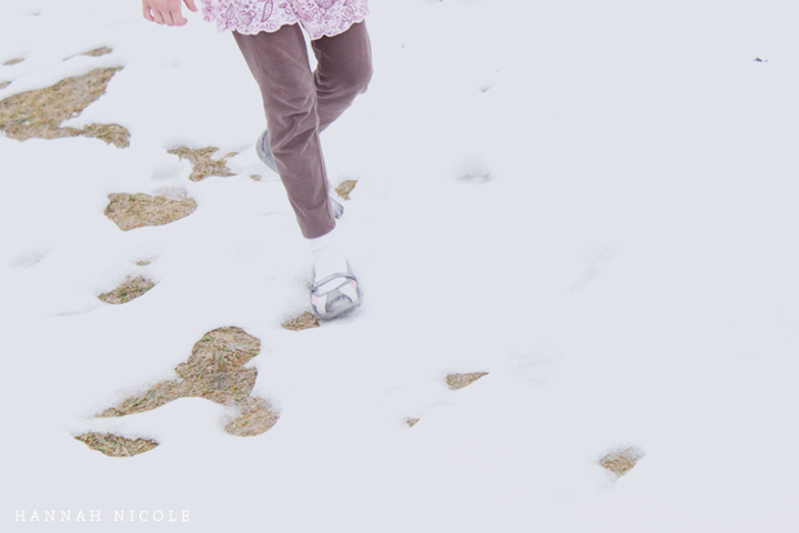 a woman wearing winter clothes walks through the snow