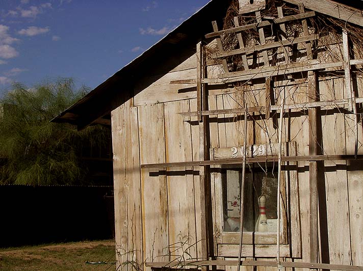 an old, rundown wooden building stands in the country