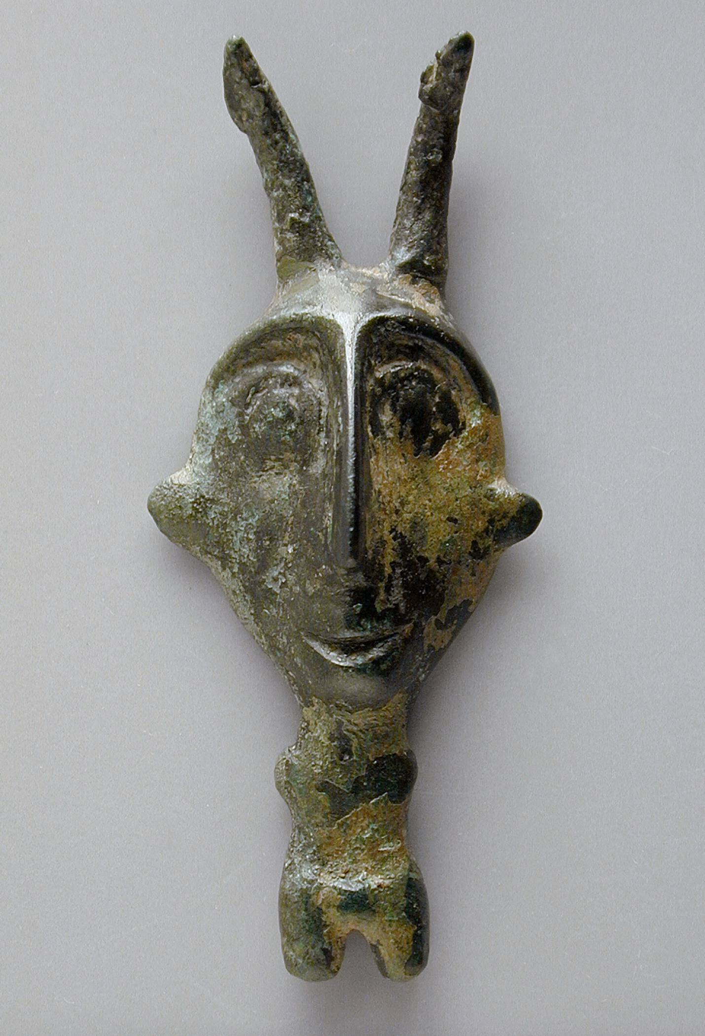 an old and rusty metal mask that has a face