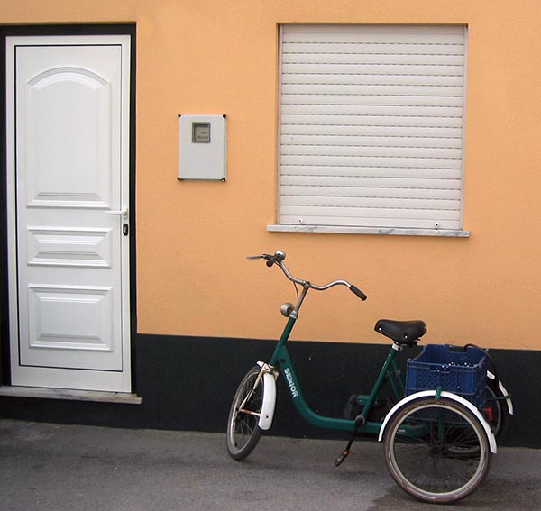 a bicycle sitting next to a yellow building