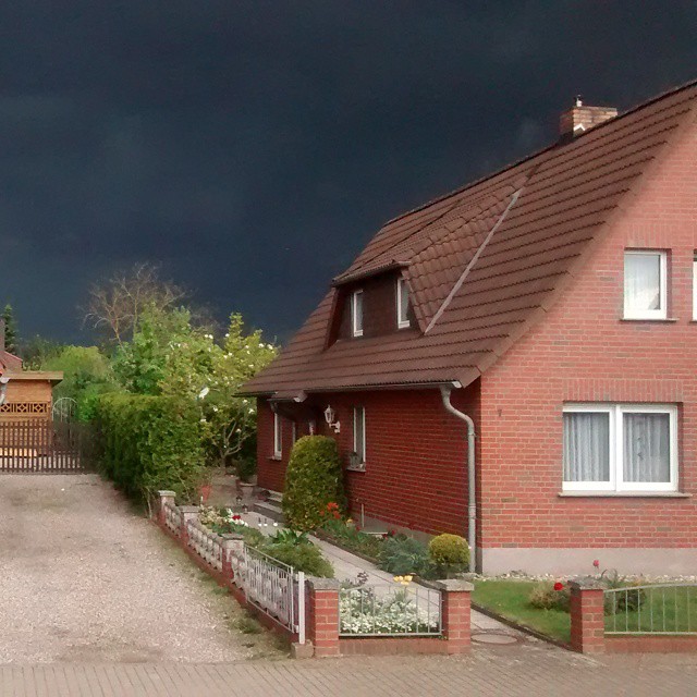storm clouds are above red brick houses