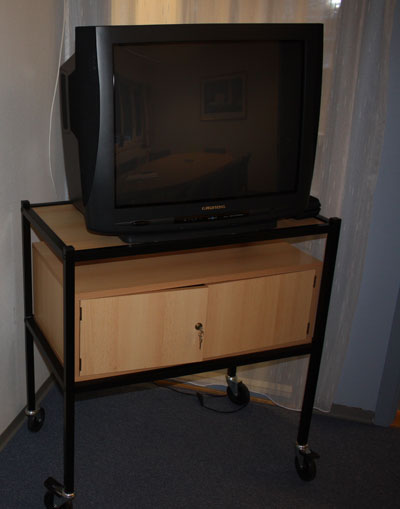 a television is on top of a small shelf