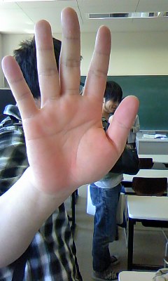 a man is holding his hand up in front of a class room