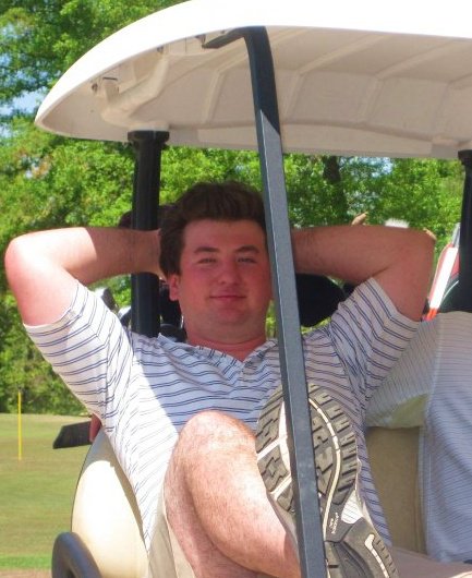 a man sits in the back of a golf cart