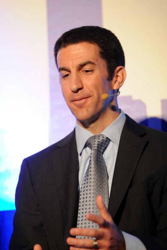a person wearing a jacket and tie holding a microphone