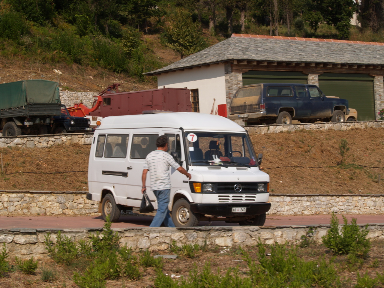 two men in a parking lot beside a white van