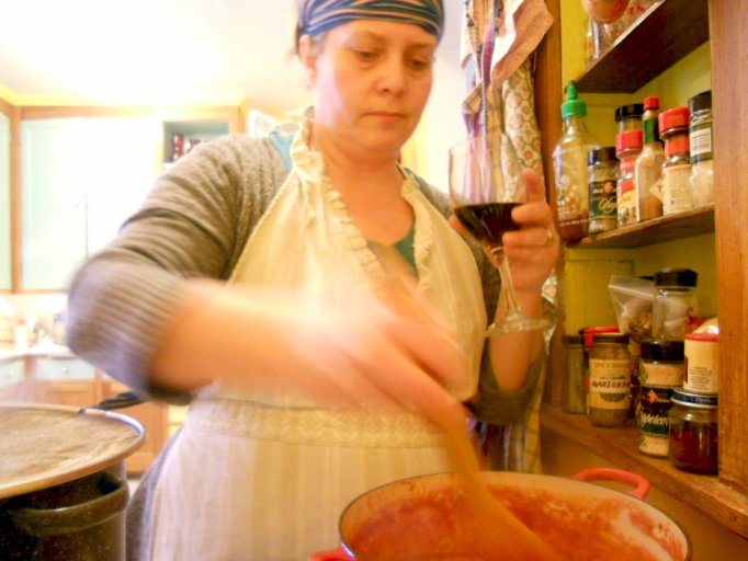 a woman pouring liquid in a pot on the kitchen counter
