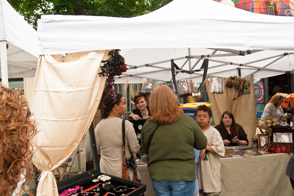 people looking at items on tables in an outdoor market