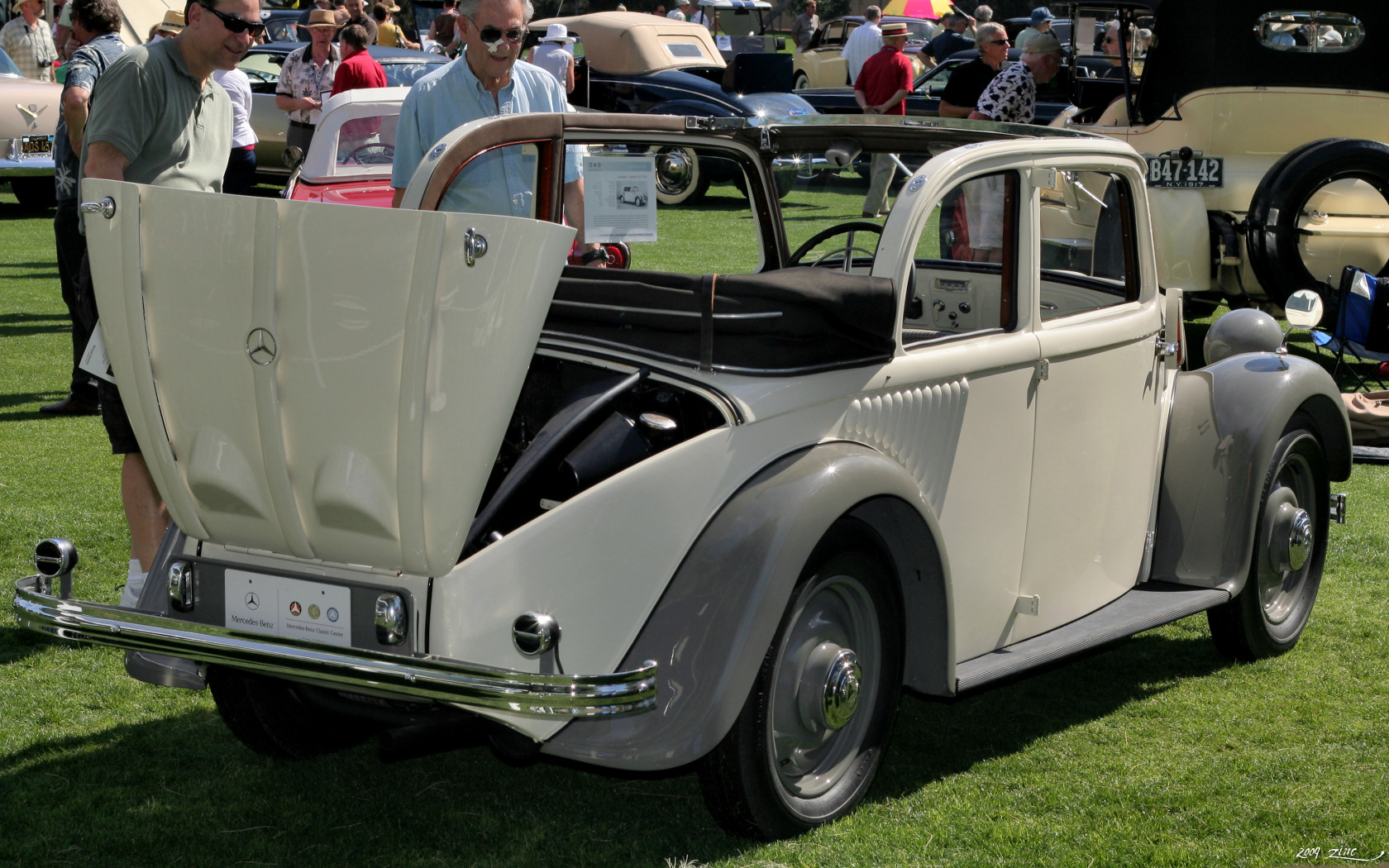 a car sitting in the grass by a tent