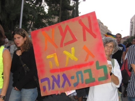a crowd of people are carrying signs on a sidewalk