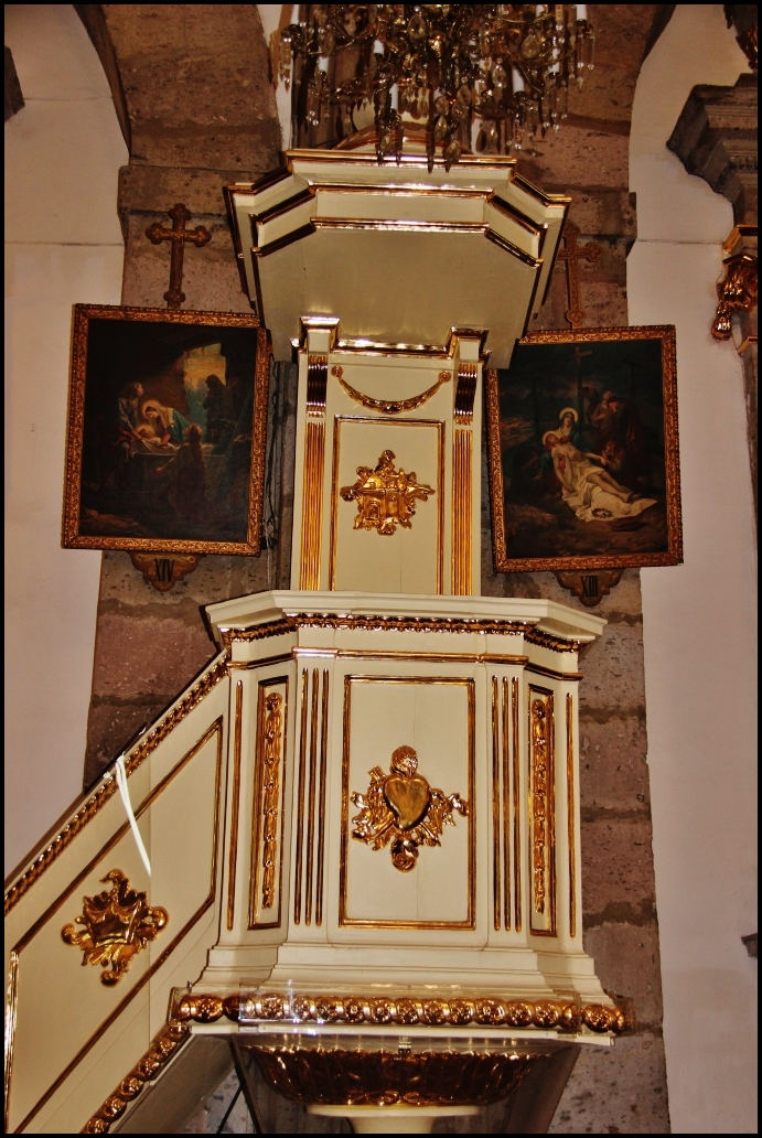 a church steeple with gold decoration and paintings hanging up