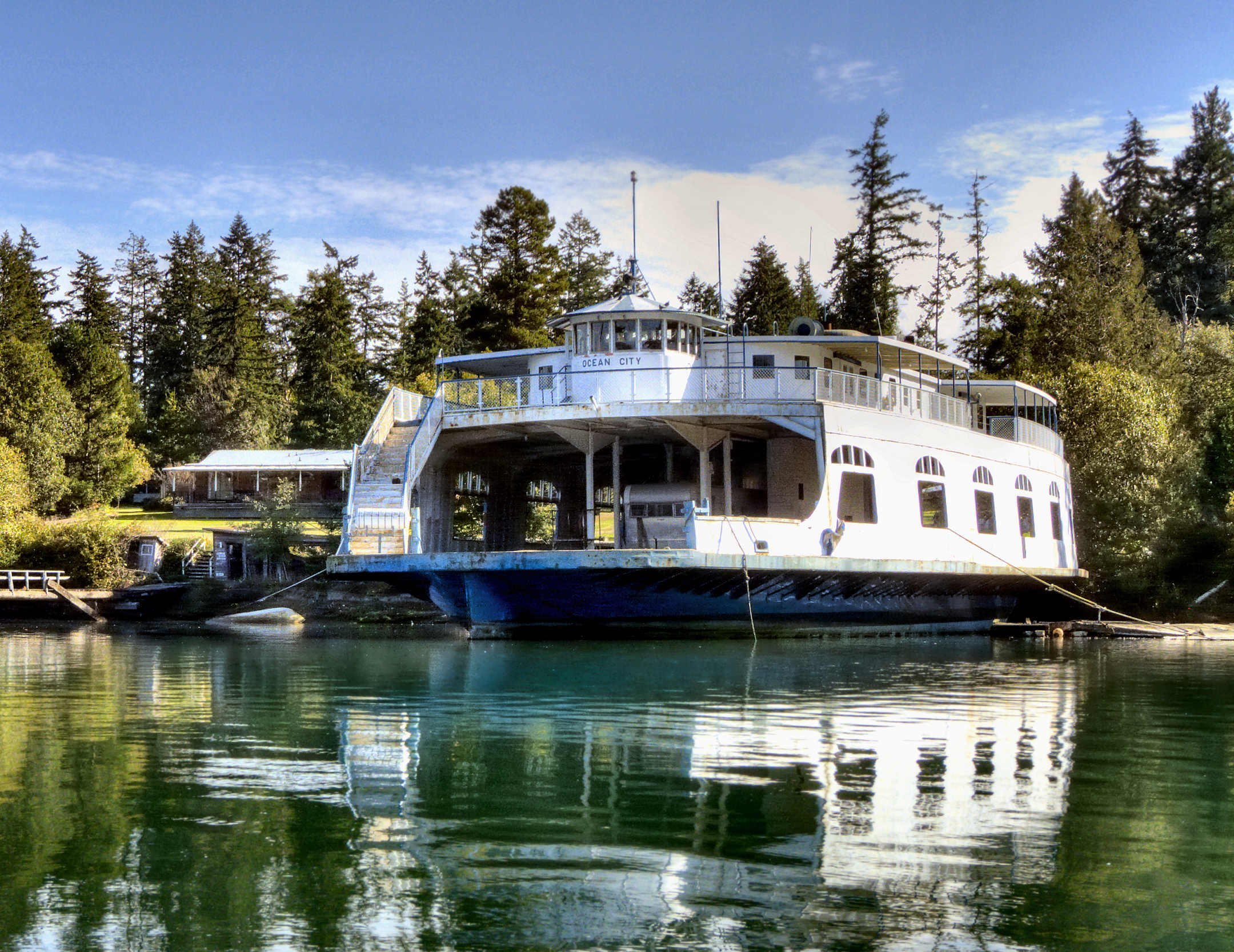 a large boat in the middle of a lake surrounded by trees