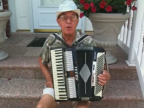 an elderly man playing an accordion on a front porch