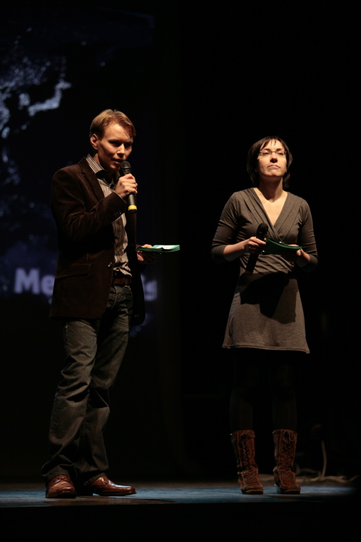 a man standing next to a woman on stage