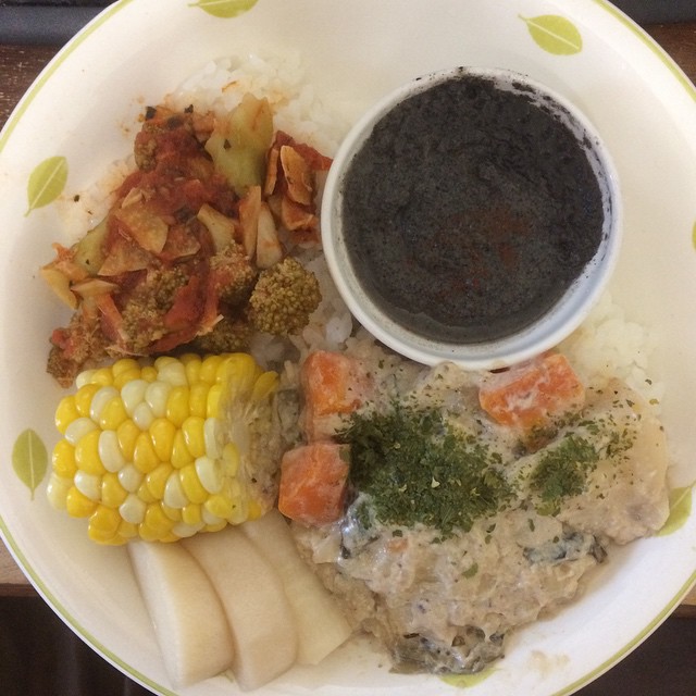 a plate of food with rice, corn, and dipping sauce