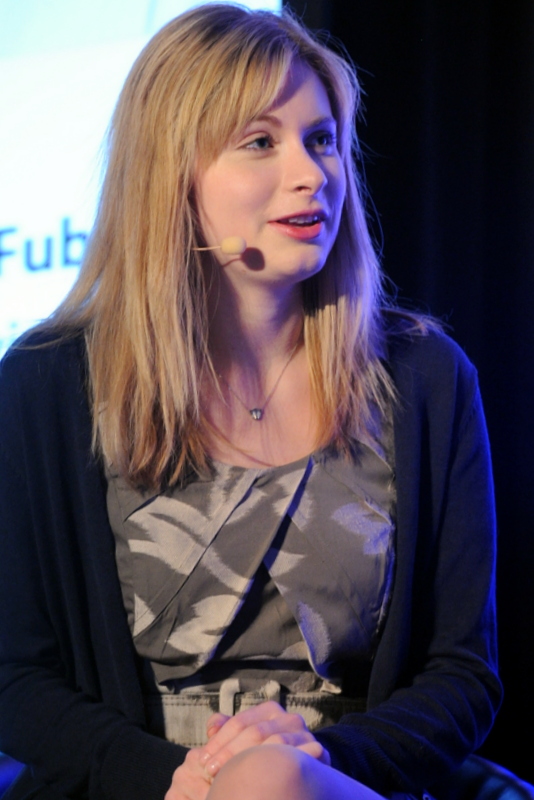 a woman is speaking at an event with a microphone in her ear