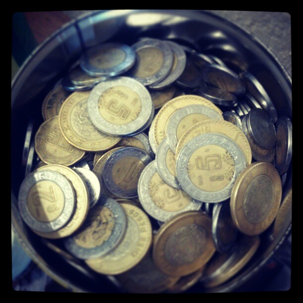 several pieces of money in a silver bucket