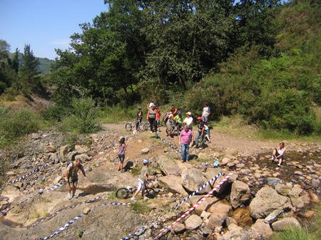 a group of people standing around on rocks and a stream