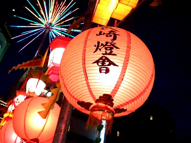bright red lanterns hang with fireworks in the background