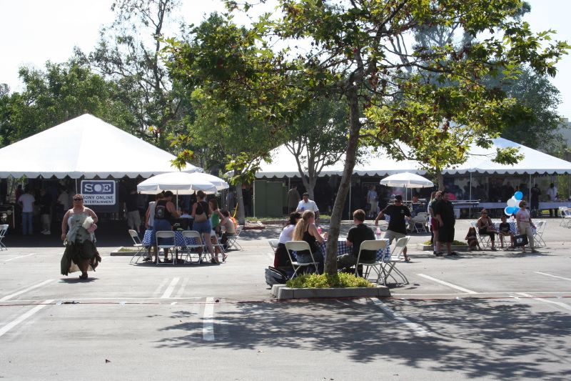 a group of people sitting under tent and trees