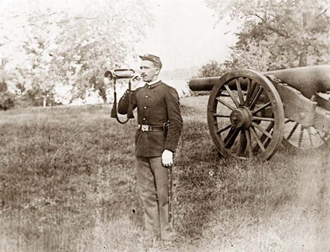 an old picture of a man in military gear holding a rifle