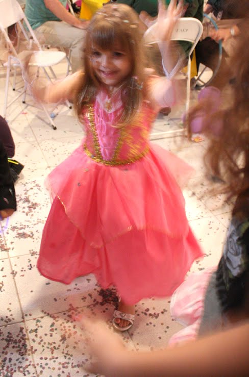 a little girl is wearing a pink dress