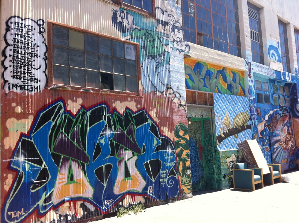 several different colors of graffiti are painted on the side of a building