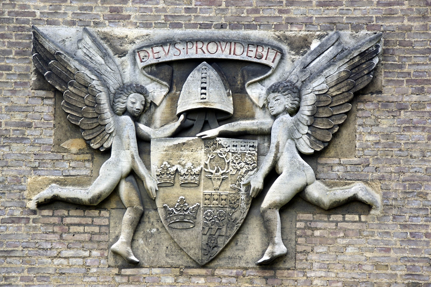 a coat of arms with two angel statues surrounding it