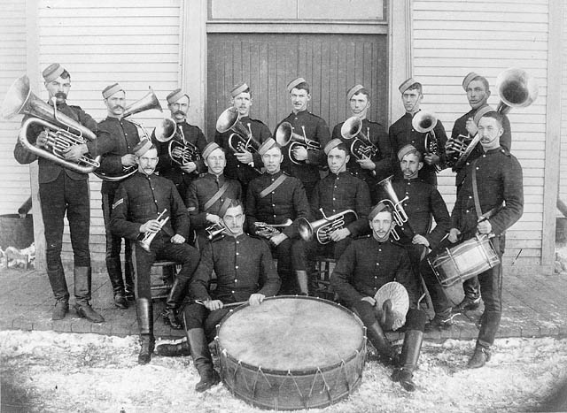 several men and women dressed in military clothes are holding musical instruments