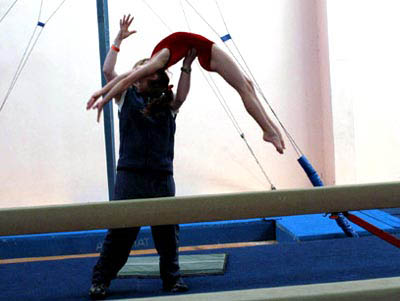 man in mid air performing aerial stunt in indoor arena