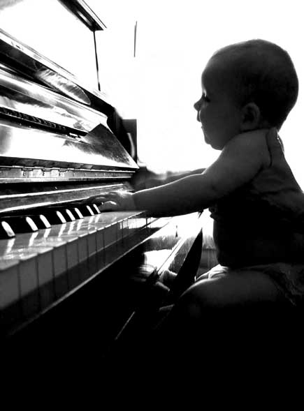 the little boy is playing with the piano