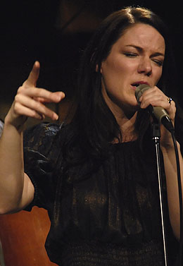 a woman singing into a microphone while holding a microphone