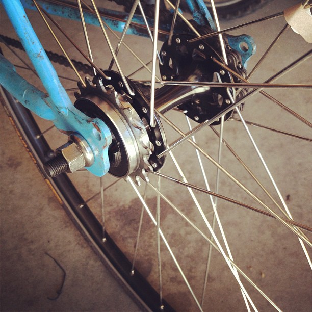a blue bicycle with gears, and a hub in the wheel