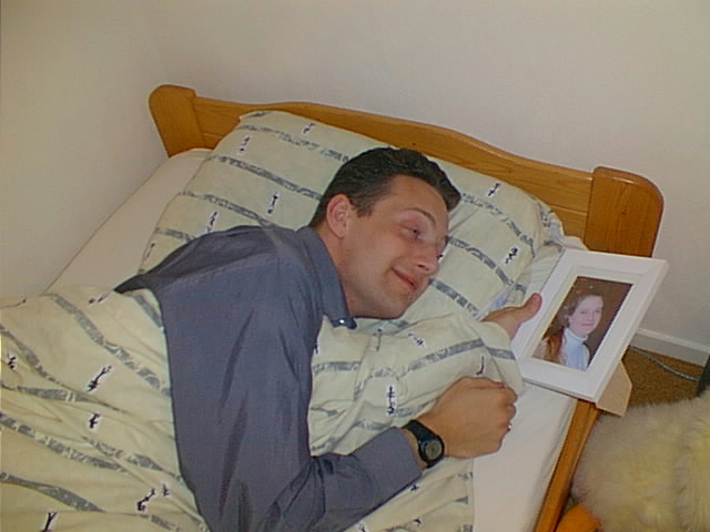 a man laying in bed with a picture of himself with his child