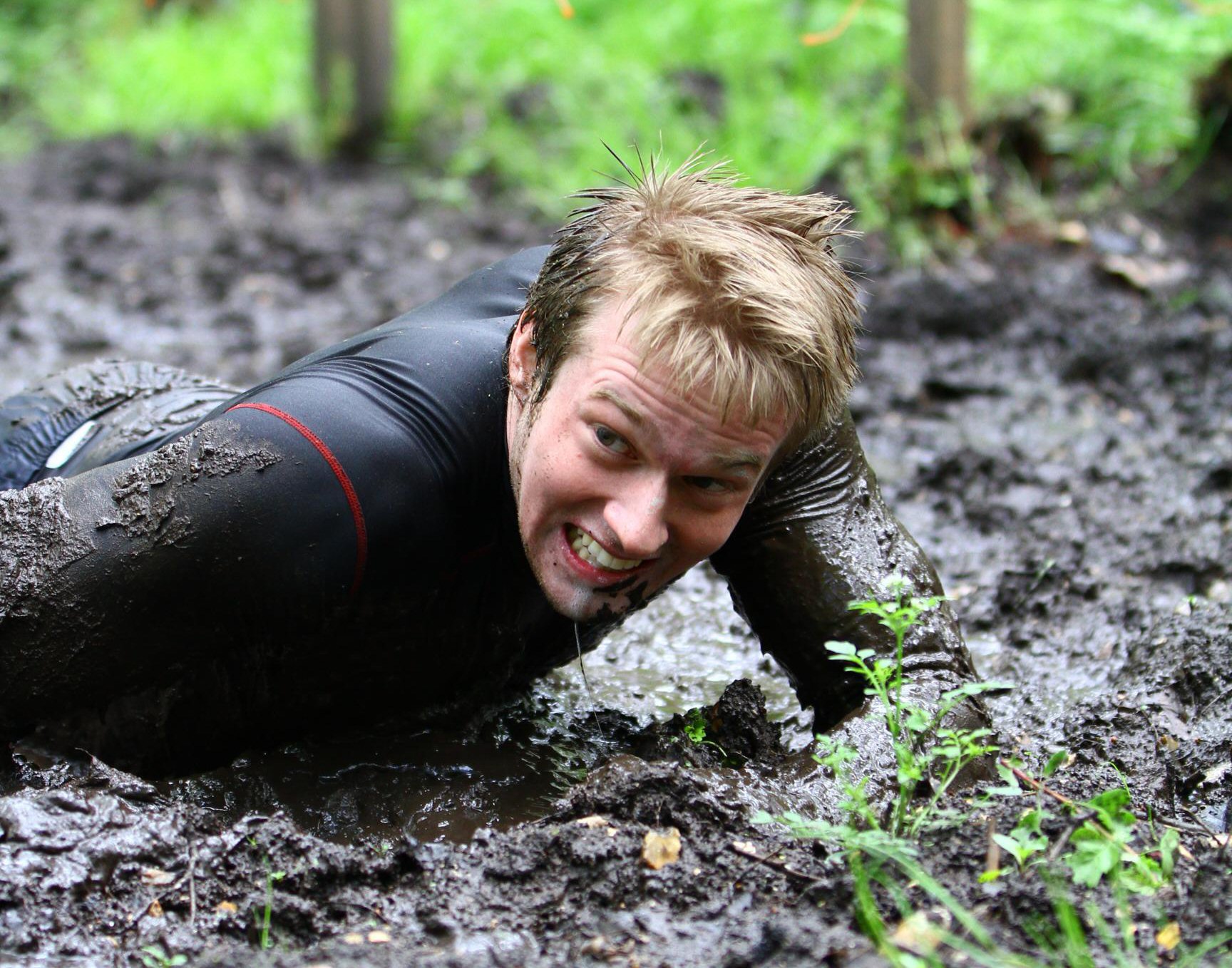 a man in the mud, in a wet suit and diving