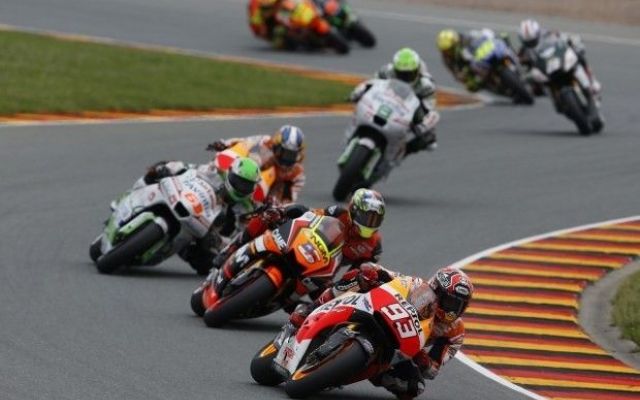 a bunch of motorcycles racing along a curve