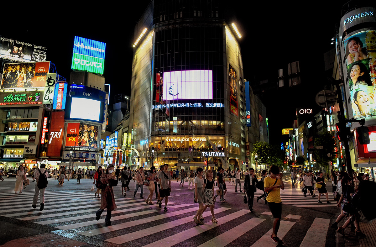 a group of people walking across a cross walk