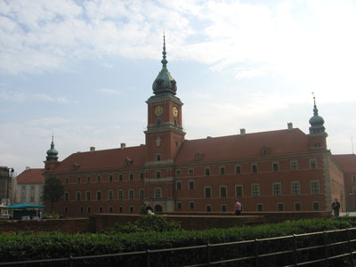a large brick building has two towers and a clock at the top