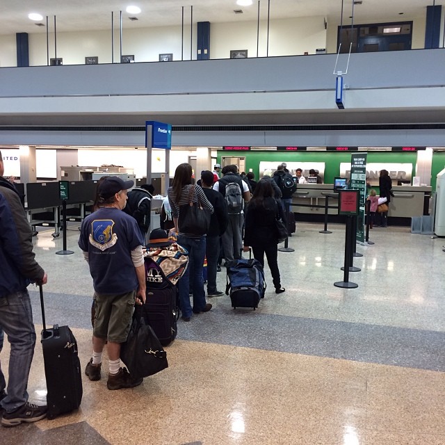several people are standing in a line at the airport