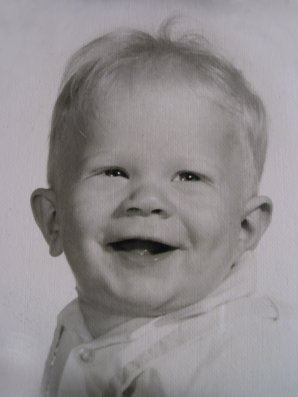 black and white pograph of a baby's face with a happy expression